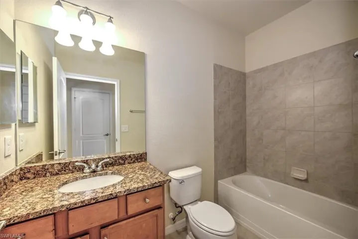 Another bathroom, as part of a mini 'suite' adjacent to Bedroom 4 with maple cabinet, granite vanity top & tiled tub - shower walls for Bedroom 4!