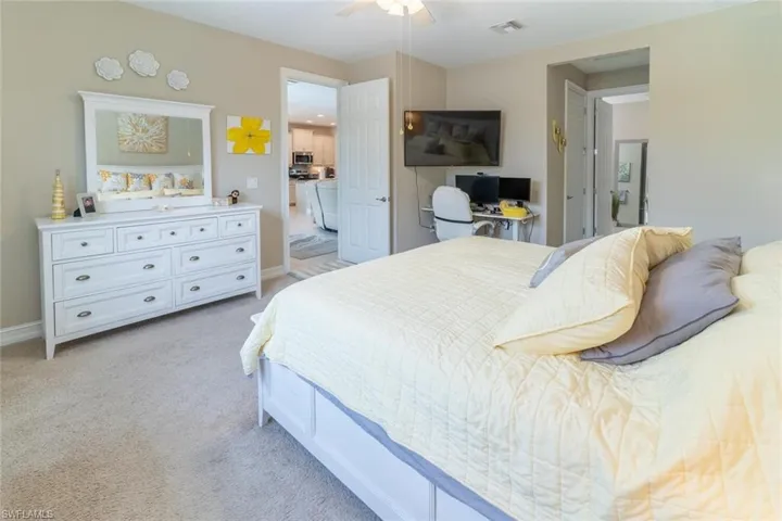 Carpeted bedroom featuring ceiling fan