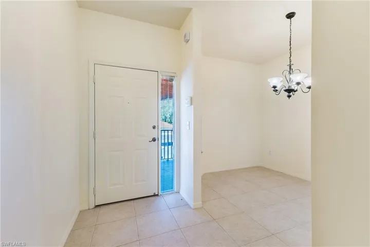 Foyer entrance featuring light tile patterned flooring and hanging lights