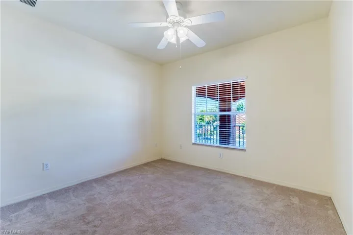 Spare room with carpet and a ceiling fan