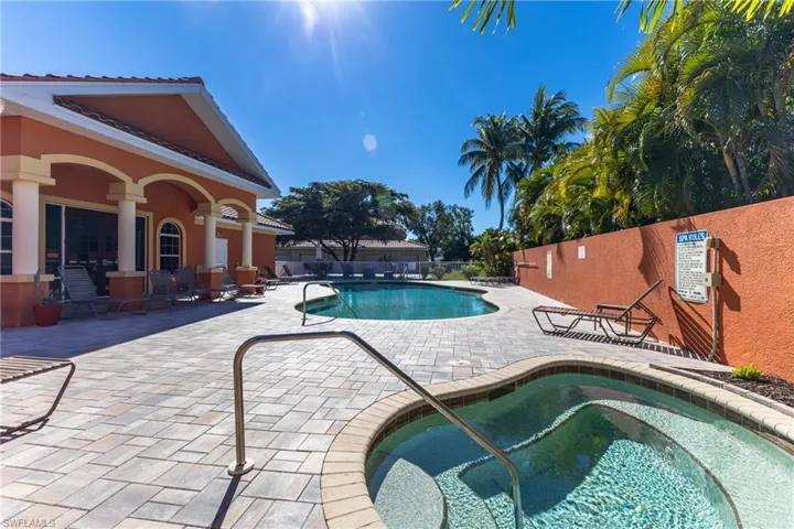 Community pool with a hot tub and a patio