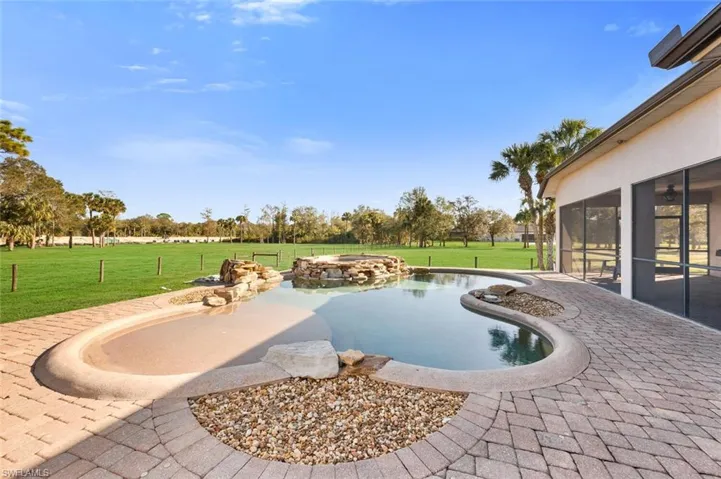View of swimming pool with a lawn, a sunroom, and a patio