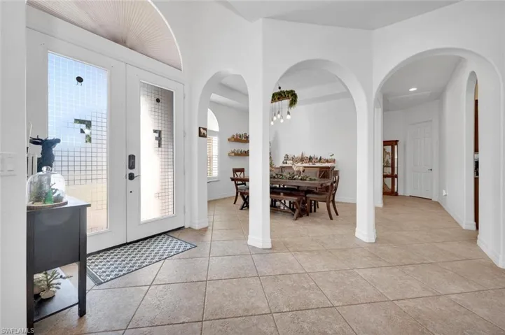 Entrance foyer with french doors and light tile patterned floors