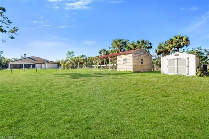 View of yard featuring a carport and a storage shed