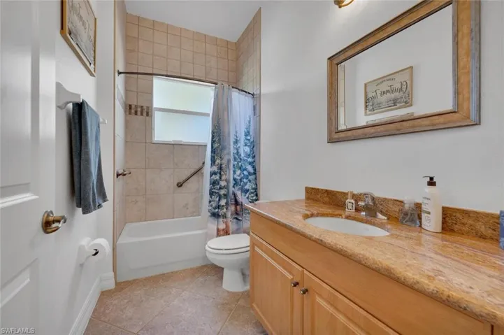 Full bathroom featuring tile patterned flooring, vanity, toilet, and shower / tub combo