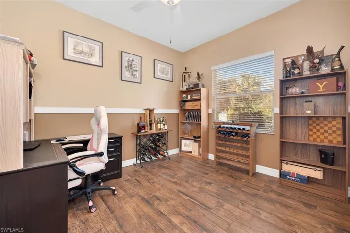 Office space with dark hardwood / wood-style floors and ceiling fan