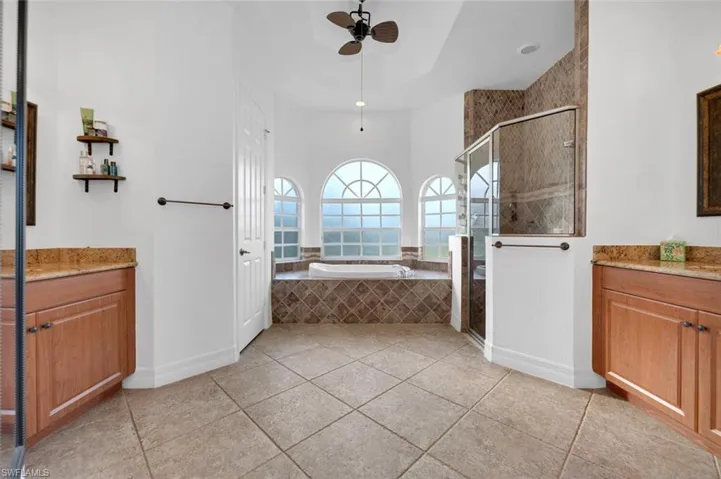 Bathroom with shower with separate bathtub, vanity, tile patterned floors, and ceiling fan
