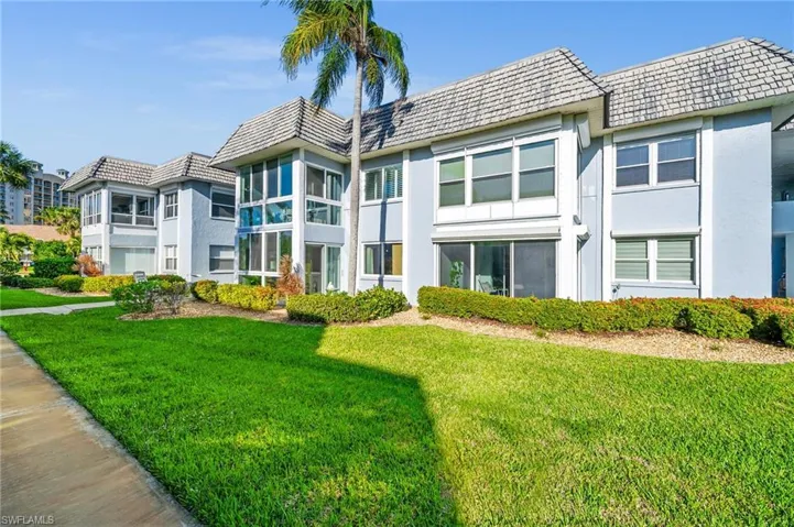 Back of property featuring a lawn