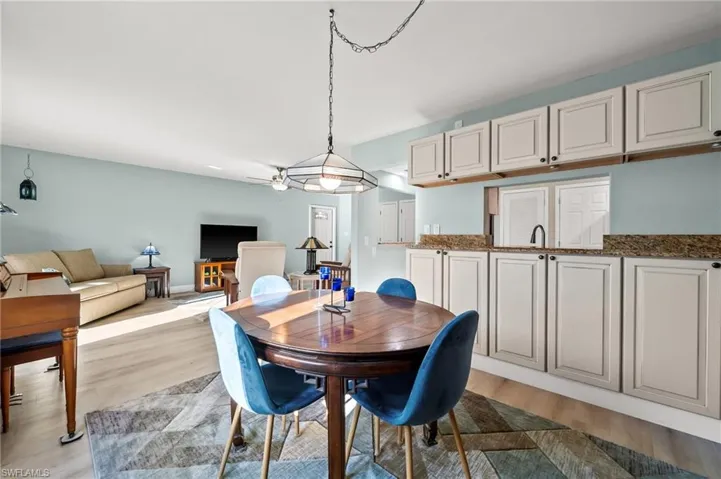 Dining space with sink and light wood-type flooring