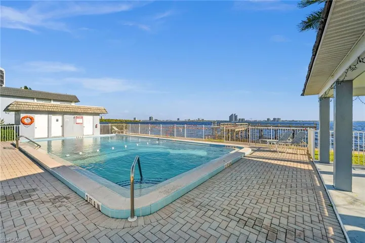 View of swimming pool featuring a water view and a patio