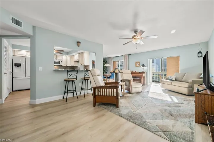Living room with ceiling fan and light wood-type flooring