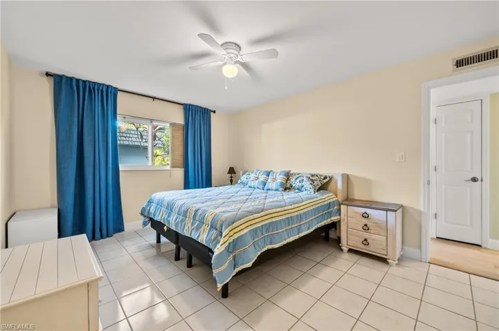Tiled bedroom featuring ceiling fan
