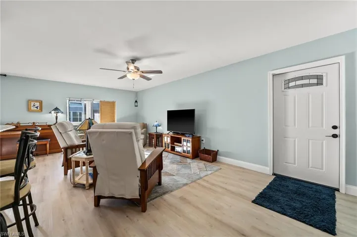 Living room with ceiling fan and light wood-type flooring