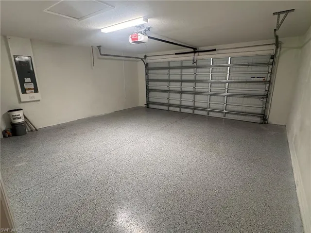 Garage featuring electric panel and a garage door opener
