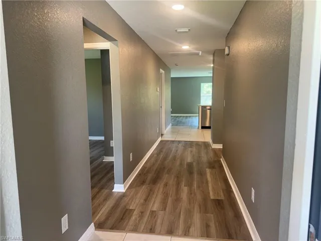 Hall featuring a textured wall and wood finished floors