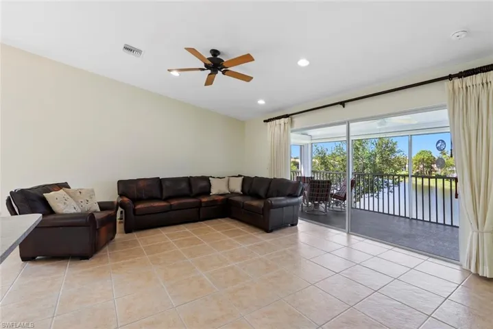 MOVE IN READY Living area featuring light tile patterned floors, a ceiling fan, a water view, and recessed lighting