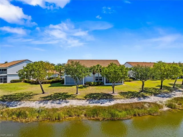 Rear view of house featuring a yard and a water view