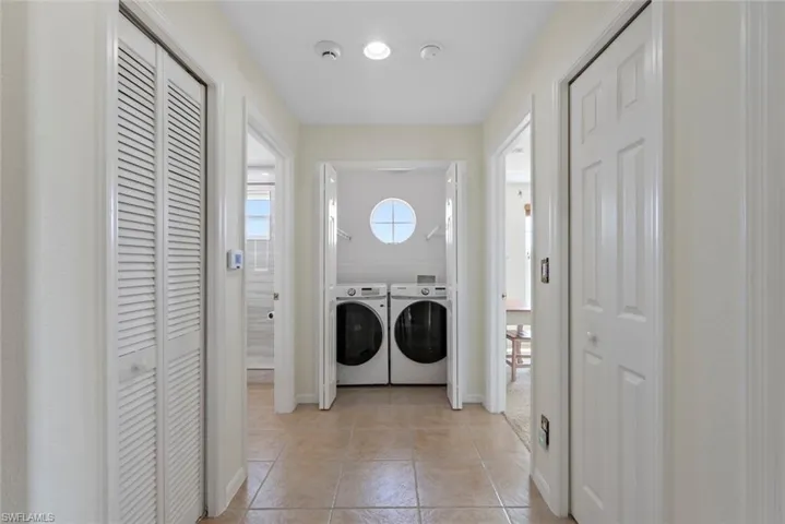 Washroom featuring light tile patterned floors and independent washer and dryer
