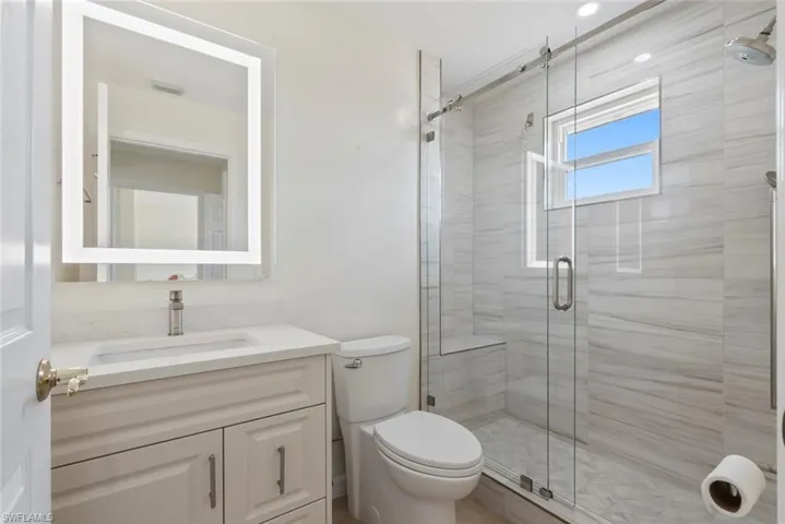 Full bathroom with vanity and a stall shower
