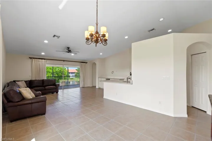 MOVE IN READY Living room with arched walkways, a chandelier, light tile patterned floors, recessed lighting, and a ceiling fan