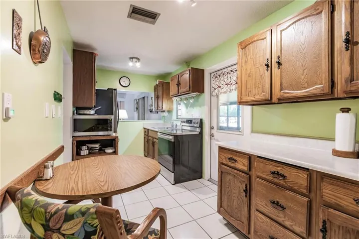 Kitchen with sink, light tile flooring, and stainless steel appliances