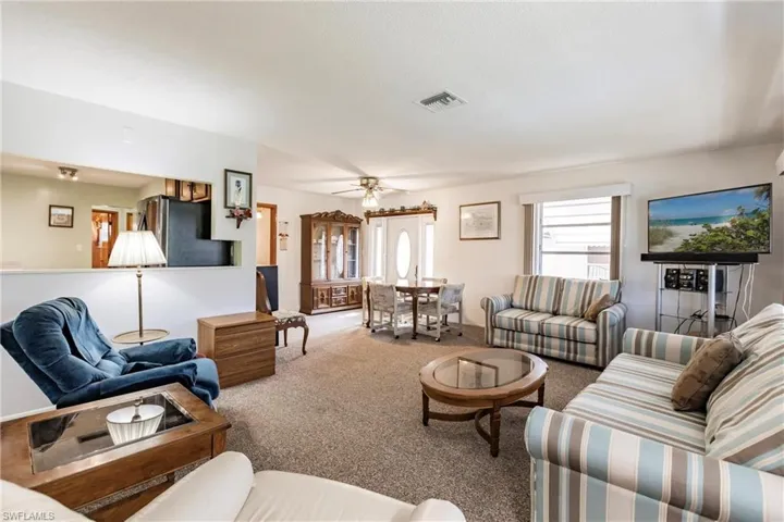 Carpeted living room featuring ceiling fan