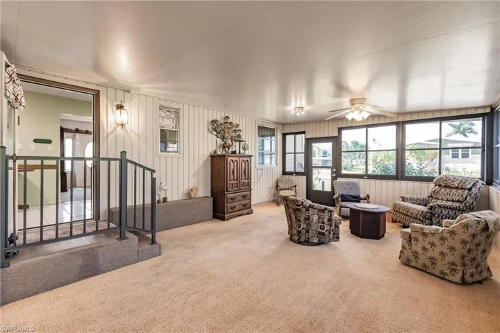 Carpeted living room with ceiling fan