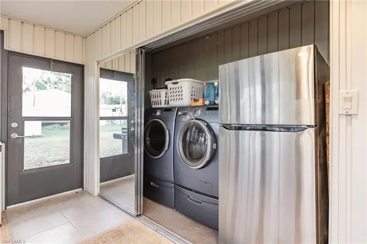 Laundry area featuring washing machine and dryer and light tile flooring