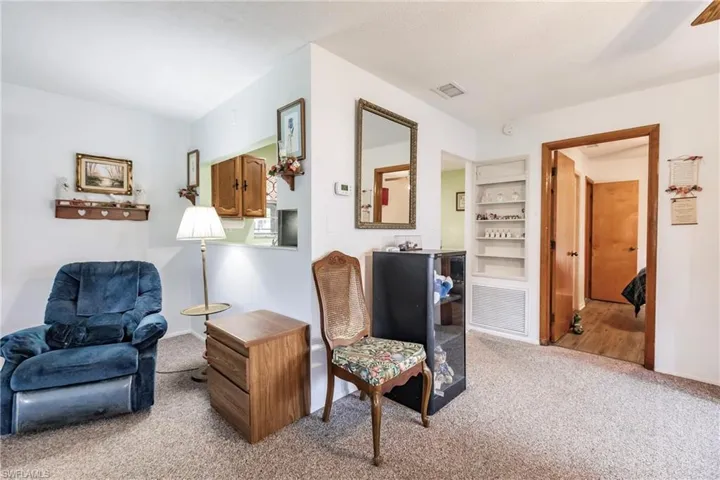 Sitting room with carpet flooring and built in shelves