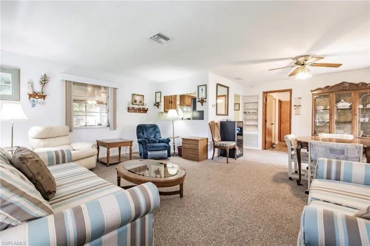 Living room with carpet and ceiling fan