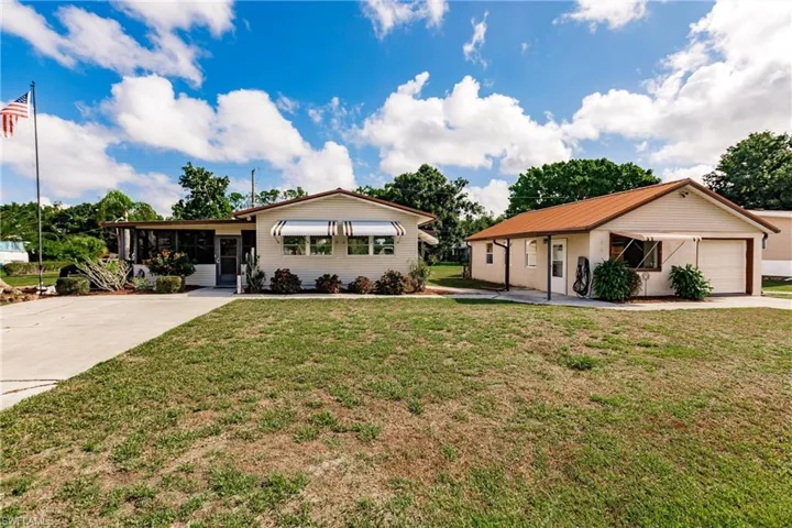 Ranch-style home featuring a garage and a front lawn