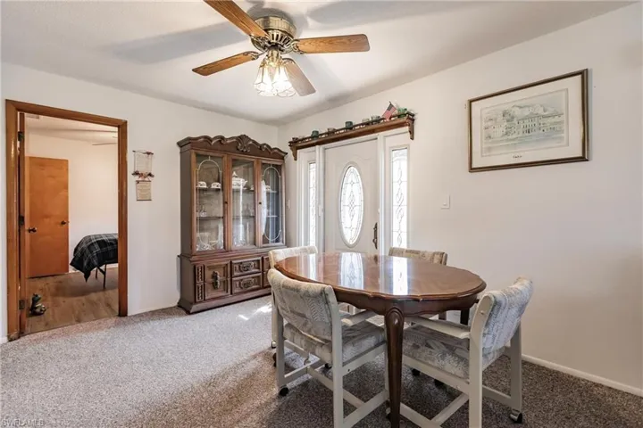 Carpeted dining room with ceiling fan