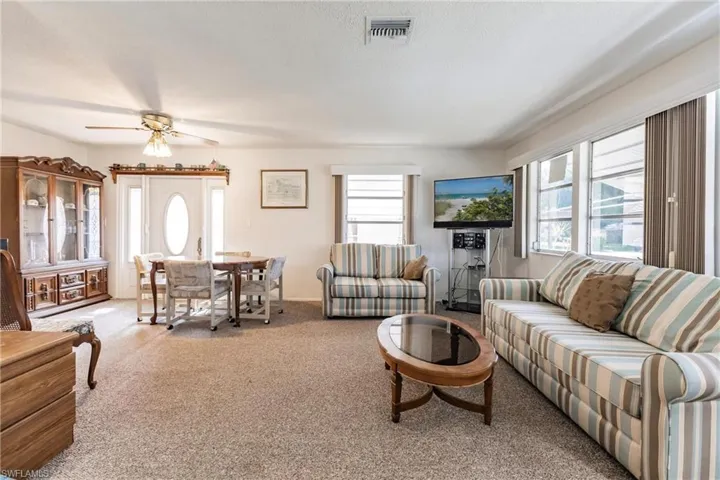 Carpeted living room with ceiling fan