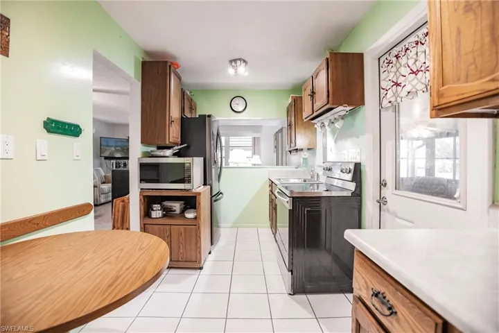 Kitchen featuring stainless steel appliances, sink, and light tile flooring