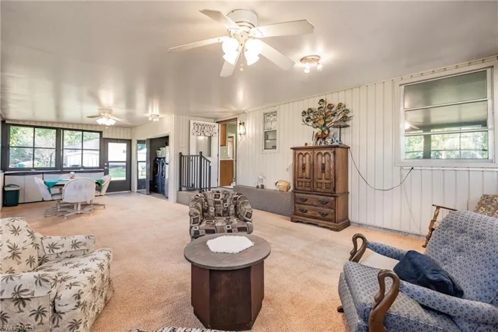 Living room featuring light carpet and ceiling fan