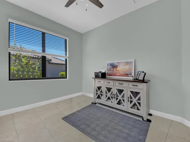 Office area featuring light tile patterned floors and ceiling fan