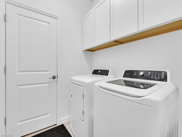 Laundry area featuring cabinet space and washer and clothes dryer