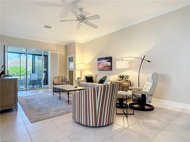 Living room featuring large tile flooring and ornamental crown molding.