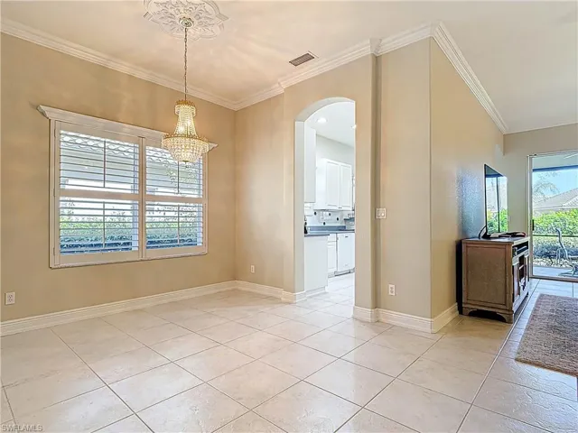 Dining room featuring, light tile patterned flooring, arched walkways, and ornamental molding