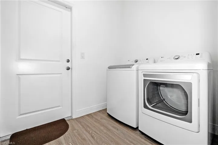 Laundry area featuring light wood finished floors and washer and dryer