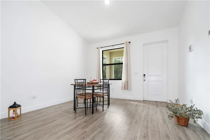 Dining space featuring vaulted ceiling and light wood-type flooring
