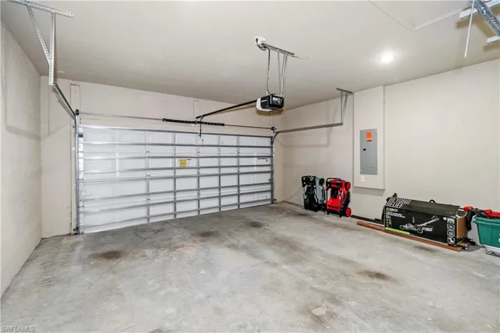 Garage featuring electric panel and a garage door opener