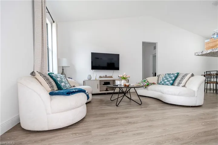 Living area with light wood-type flooring and lofted ceiling