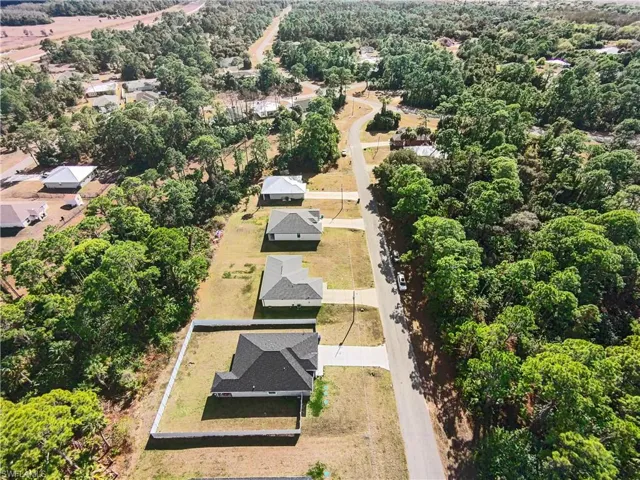 Aerial view of property and surrounding area featuring nearby suburban area