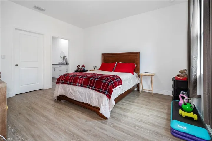 Bedroom featuring light wood-style floors and connected bathroom