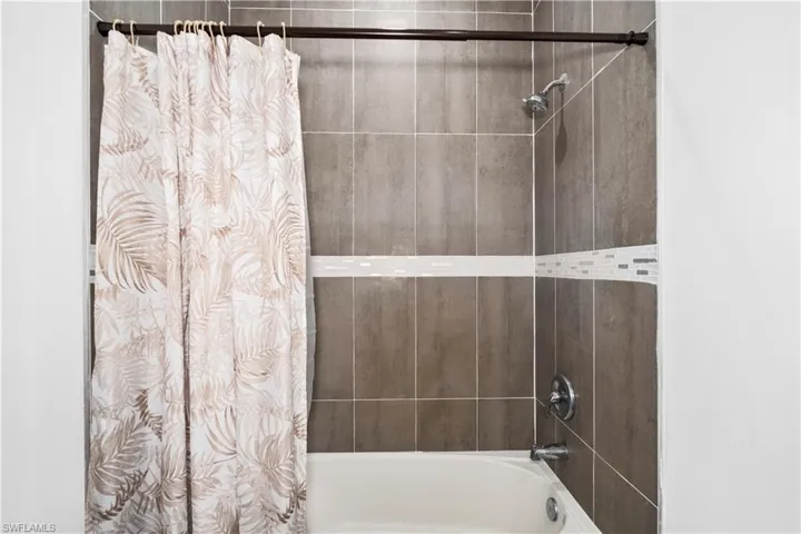 Bathroom with shower / bath combination with curtain