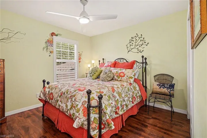 Bedroom with dark wood-style floors and a ceiling fan