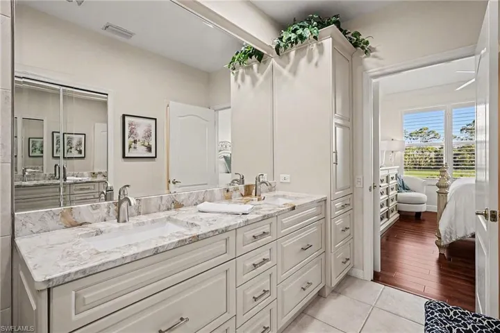 Ensuite bathroom with double vanity and light tile patterned floors
