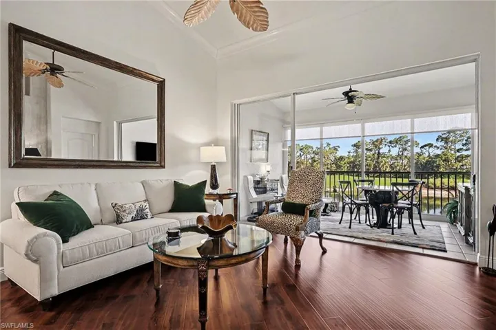 Living area featuring a ceiling fan, wood finished floors, and ornamental molding
