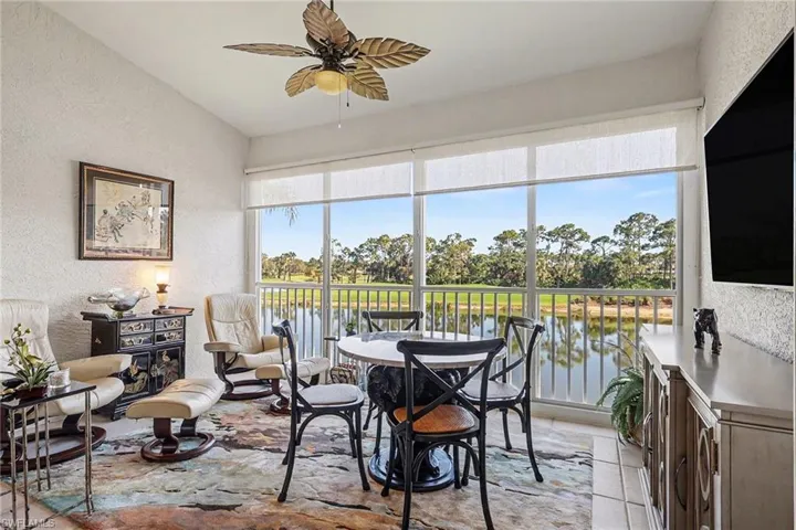 Dining space featuring a textured wall, ceiling fan, plenty of natural light, water and golf course view
